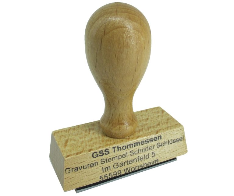 Holzstempel mit gravierter Aufschrift und rundem Stempelkopf.
